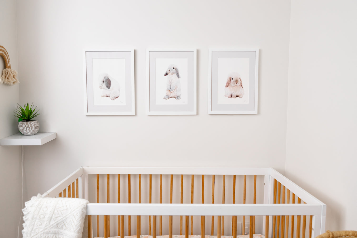 Minimalist nursery room with Alice, Alfie and Snowball framed bunny prints on the wall