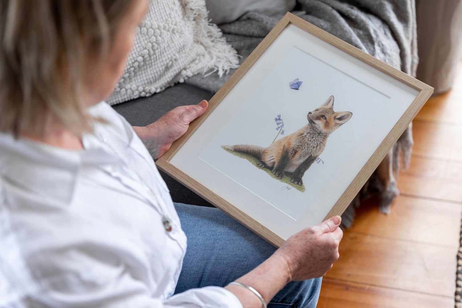 Artist Jo holding a framed print of her Woodland Fox
