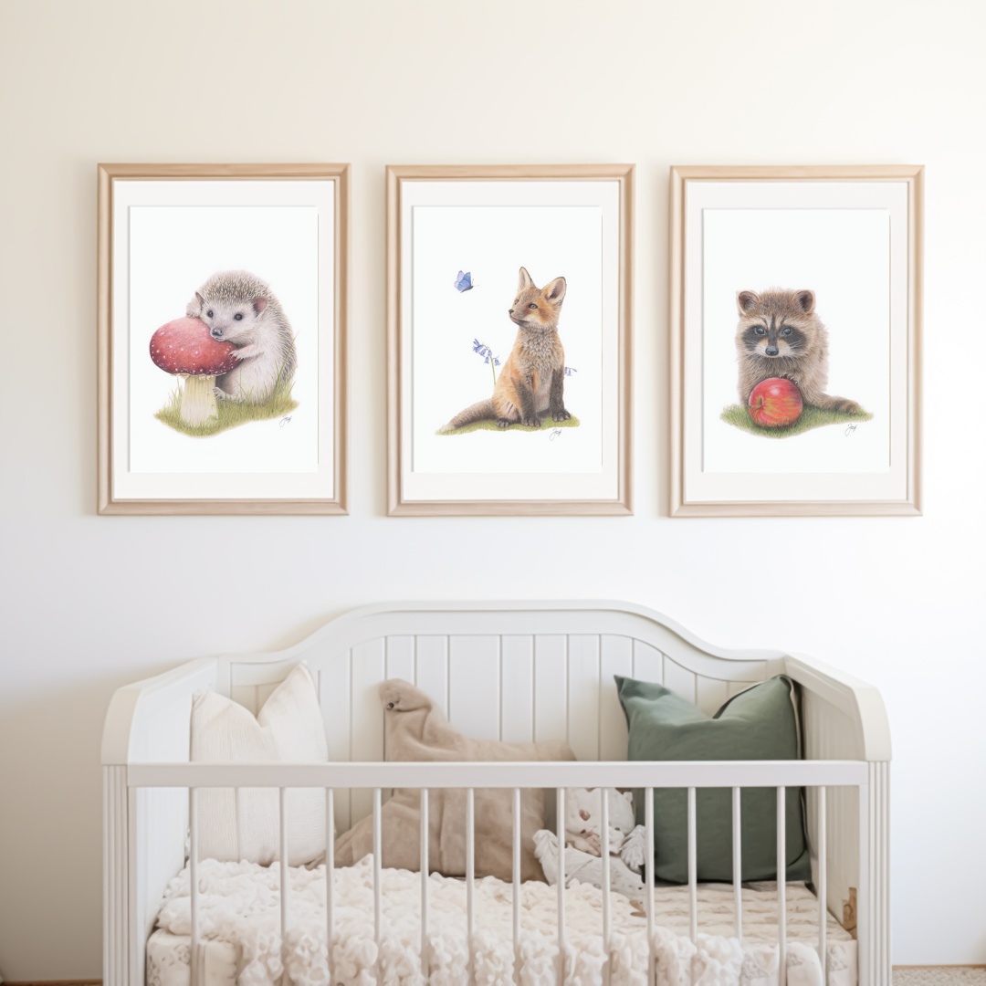 Framed prints of the Woodland Hedgehog, Fox and Raccoon on a nursery wall